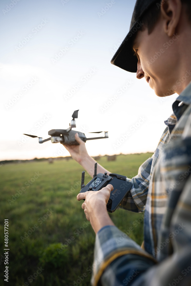 Fototapeta premium Farmer with drone on a field. Smart farming and precision agriculture