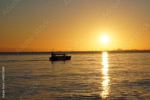 łódka na morzu o wschodzie słońca