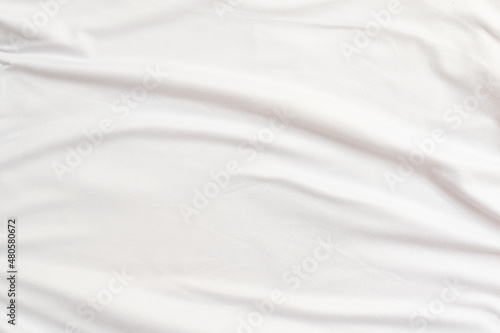 Closeup rippled soft white fabric texture background.
