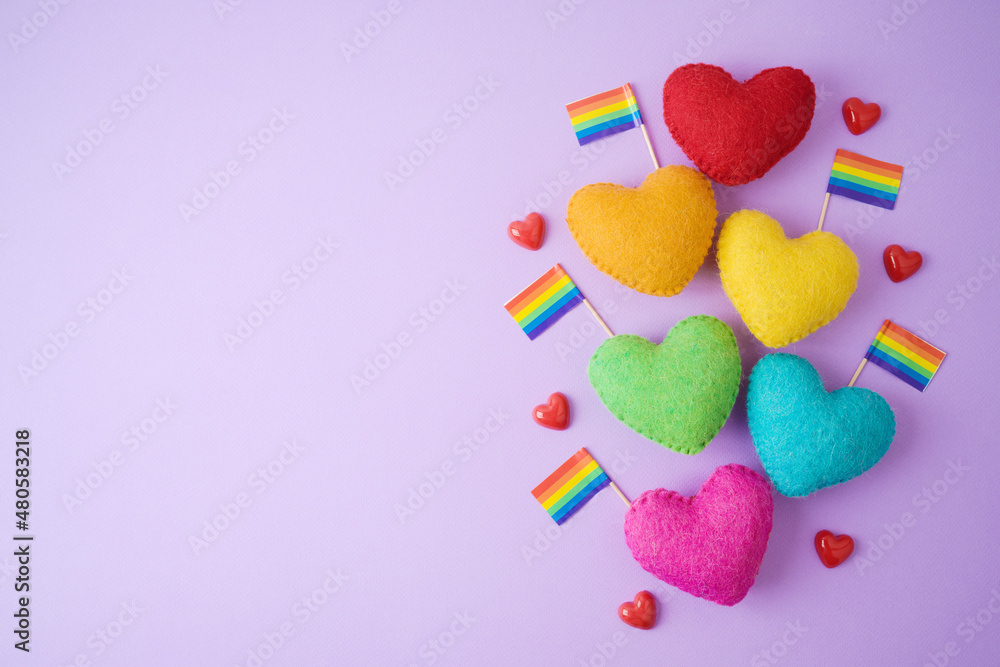 Fototapeta premium Happy Valentines day concept with heart shapes and rainbow flag on purple background. Flat lay composition