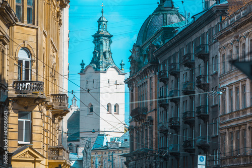 Photos view of lviv street with cathedral church tower between buildings