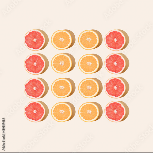 Minimal fruit pattern with orange and grapefruit on pastel sand background. Flat lay creative summer mood. Summer vibes. Beach party. Organic food. Orange juice. Trendy pattern with fruit.