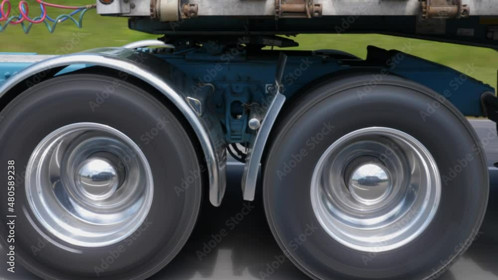 Driving beside commercial tractor trailer. Detail of chome wheels and trailer hitch. Highway driving in Ontario, Canada. Driving beside commercial tractor trailer. Detail of chome wheels and trailer hitch. Highway driving in Ontario, Canada.