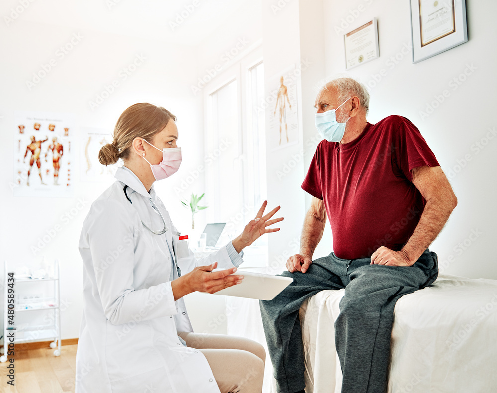 Obraz premium doctor senior patient woman medical hospital health care man medicine office corona virus mask clinic healthcare elderly talking support tablet