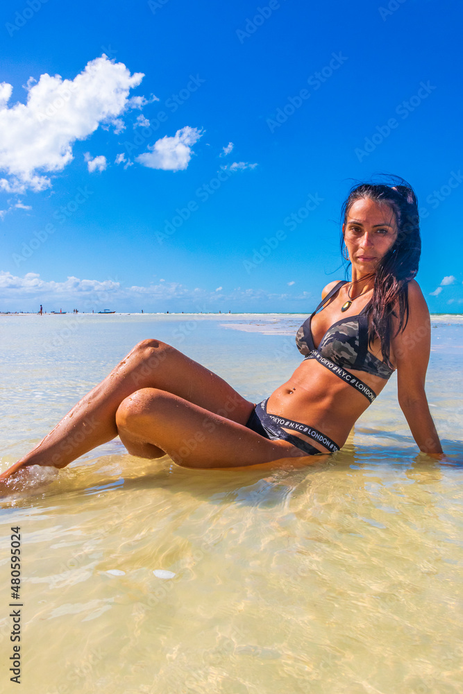 Sexy pretty woman model poses on Holbox beach sandbank Mexico.