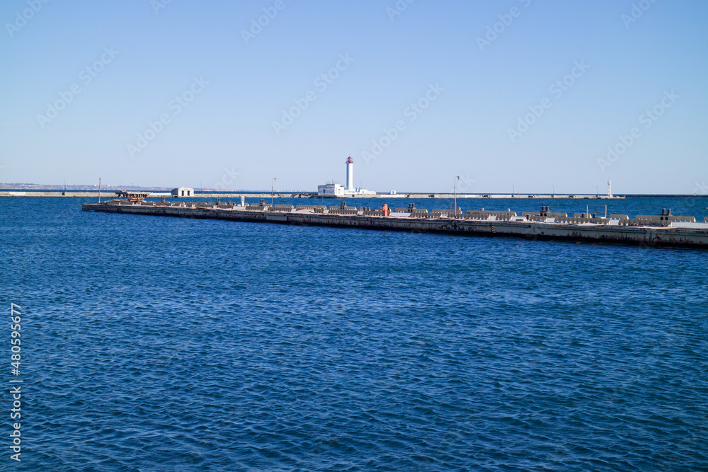 Fototapeta premium a seaport on the seashore, a lighthouse is visible in the distance, a beautiful blue sea