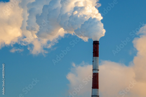 Steam from the pipes of the factory in the winter city. Powerful heating boiler room in winter. Selective focus