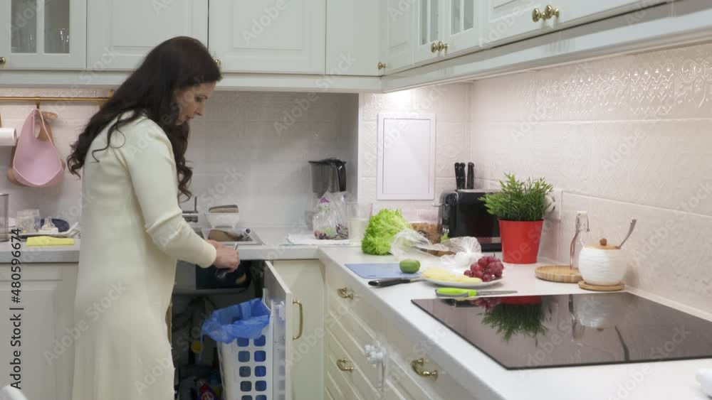 Woman cooking dinner in the kitchen peeling and slicing kiwi fruit on kitchen countertop. High quality 4k footage Woman cooking dinner in the kitchen peeling and slicing kiwi fruit on kitchen countertop. High quality 4k footage