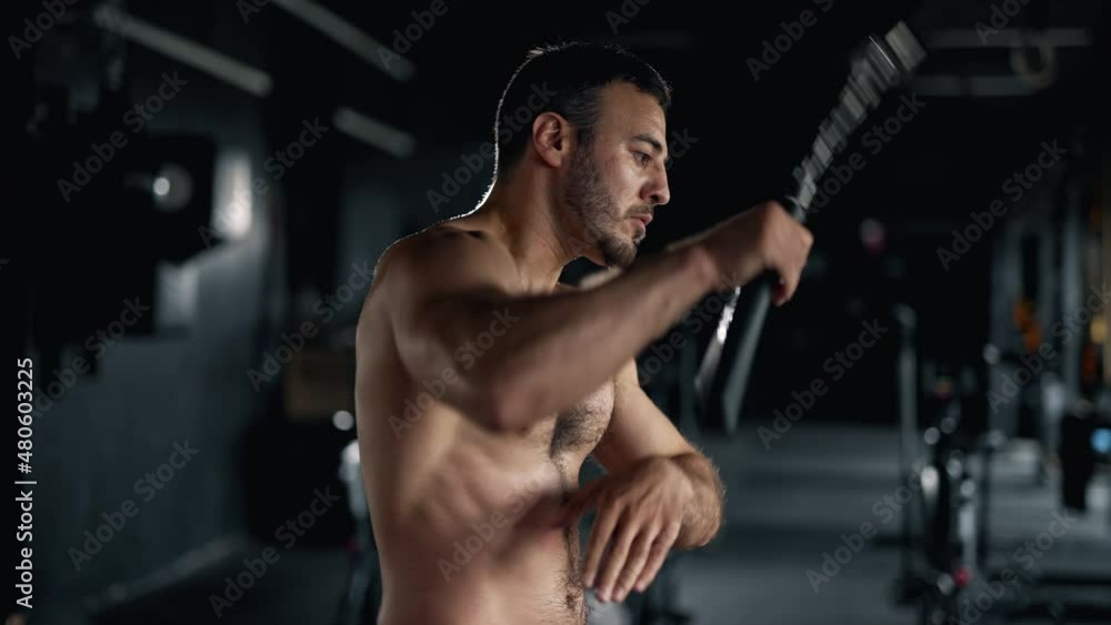 A muscular sportsman is doing exercise in the gym. Self confident man is holding nunchuck and practicing kung fu. Maximum focus and strength. Concept of martial arts health and sports. A muscular sportsman is doing exercise in the gym. Self confident man is holding nunchuck and practicing kung fu. Maximum focus and strength. Concept of martial arts health and sports.