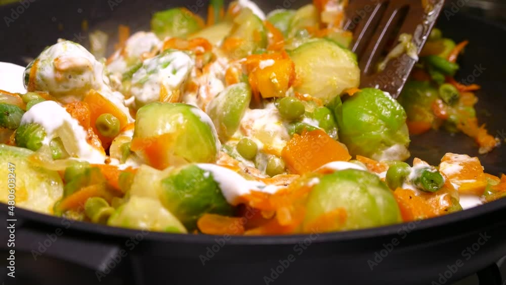 Vegetable stew cooked in a pan. Brussels sprouts, carrots, asparagus and peas. Vegetable stew cooked in a pan. Brussels sprouts, carrots, asparagus and peas.