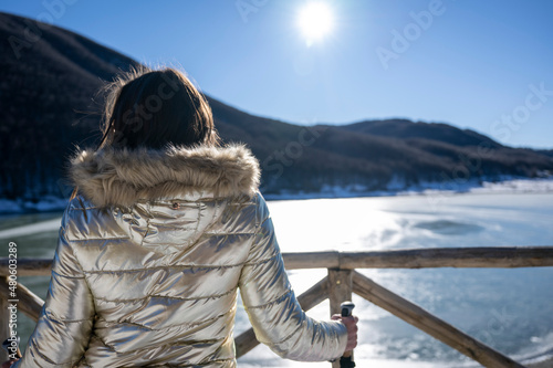 Escursionista bella donna con bastoncini e giacca oro photo