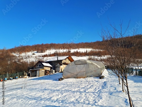 Weekend cottage with greenhouse and hills covered with snow in the village, mountain Igman, Bosnia and Herzegovina