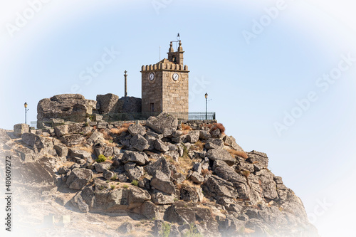 a stone christian cross and the clock tower at the Castle Hill of Meda city, district of Guarda, province of Beira Alta, Beiras and Serra da Estrela, Portugal