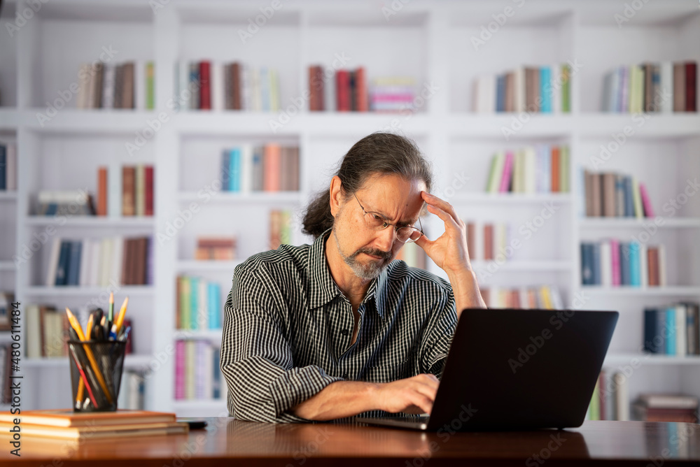 Obraz premium Angry stressed businessman reading bad news on laptop. Mad man feels frustrated about high bills, dismissal notice, bank debt, tax invoice or mistake sits at home office desk.