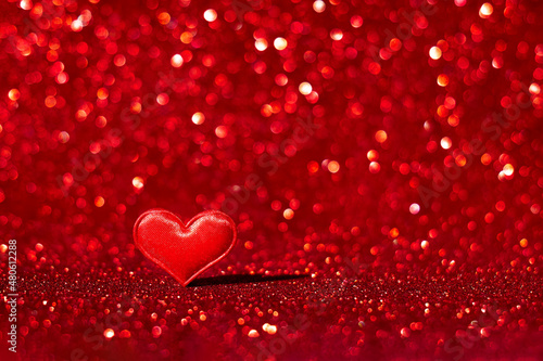 Red heart on red blurred abstract background with bokeh. San Valentine's day concept. Greeting card.