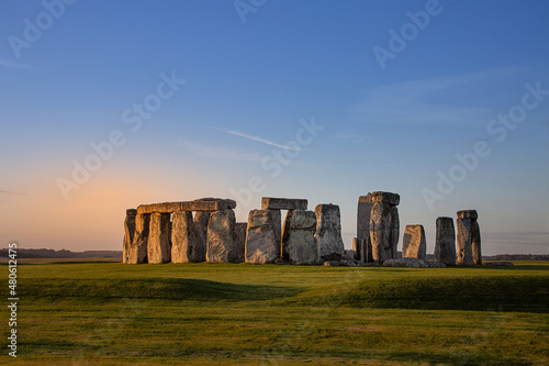 Stonehenge, a prehistoric monument during early morning. pink orange glow and blue sky photo