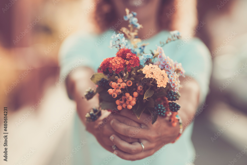 Close up of woman showing spring natural floreal bouquet in pastel tones filter. Blossom flowers and present gift concept. Close up of woman showing spring natural floreal bouquet in pastel tones filter. Blossom flowers and present gift concept.