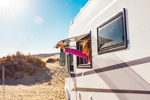 Photo Adult tourist woman opening camper van window to enjoy the sun and freedom