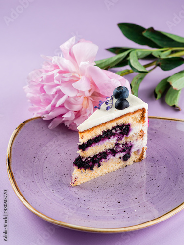 delicate piece of cake on a pink background with pink peony petals photo