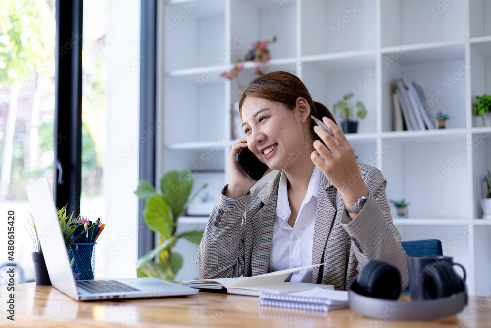 Asian woman talking on the phone with a friend to discuss a lesson, she is a student. The concept of online learning due to the COVID-19 outbreak to prevent an outbreak in the classroom.