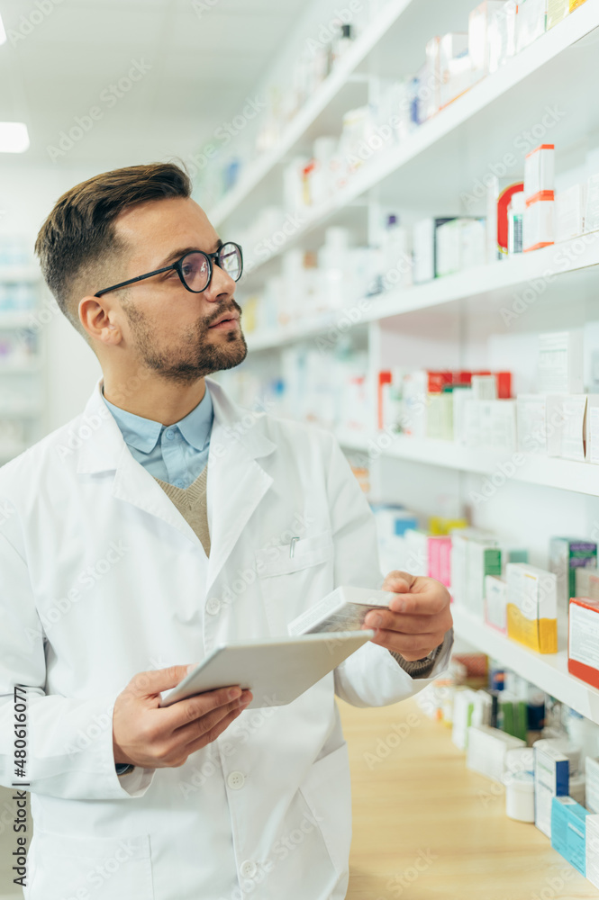 Portrait of a handsome pharmacist working in a pharmacy Portrait of a handsome pharmacist working in a pharmacy