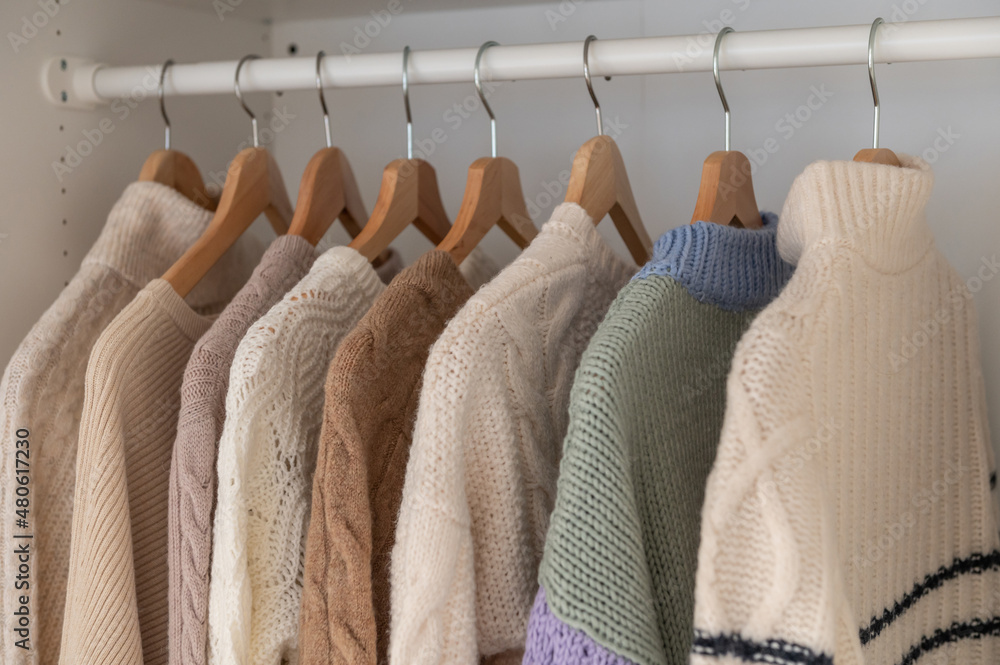 Warm beige wool pullover and knitwear and hanging in wardrobe Stock Photo Adobe Stock