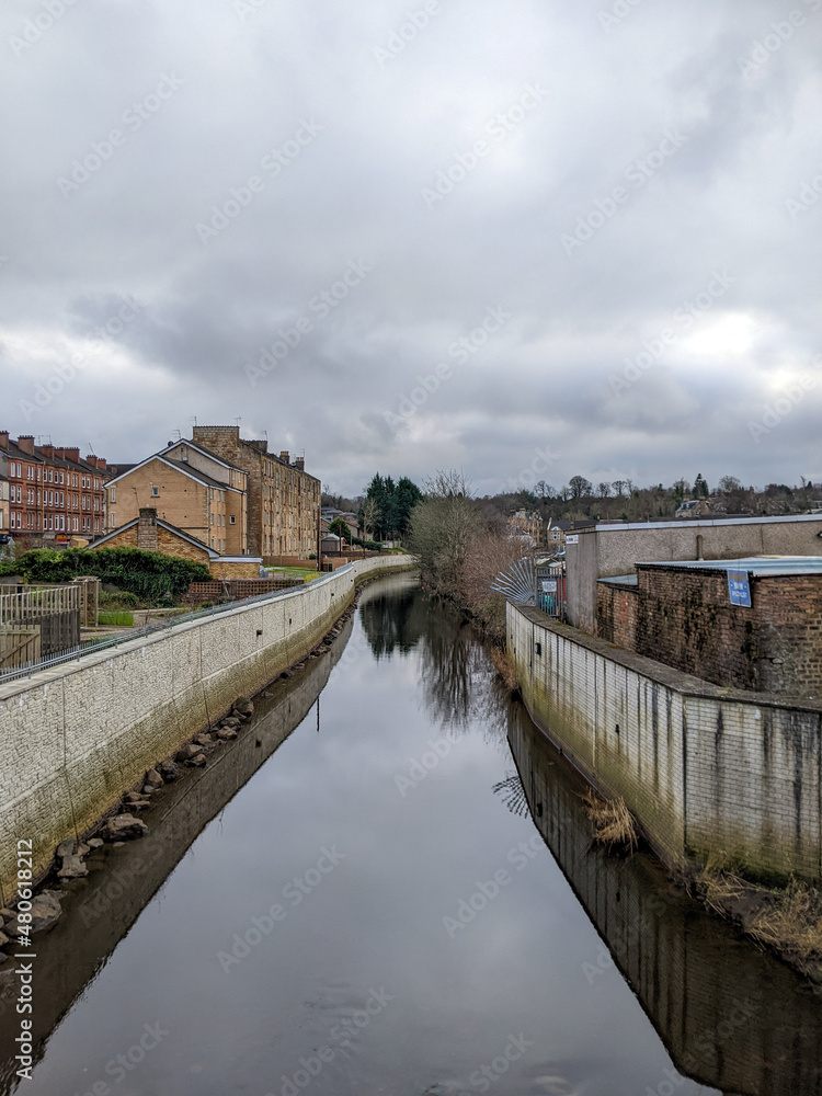 Naklejka premium A river running through a small town.