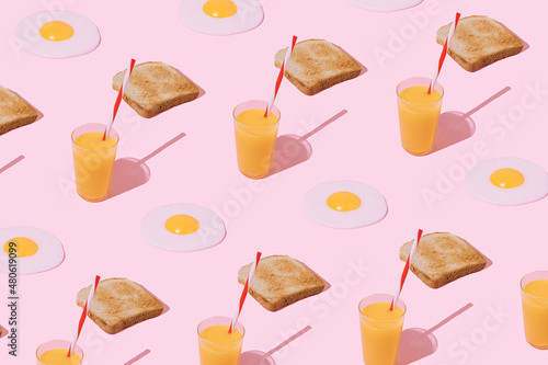 Breakfast pattern made with fried eggs, toast and orange juice on pastel pink background. Brunch time. Tasty meal. Top view. Flat lay. Time for breakfast.