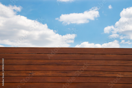 Cumaru wood deck fence pattern and blue sky background