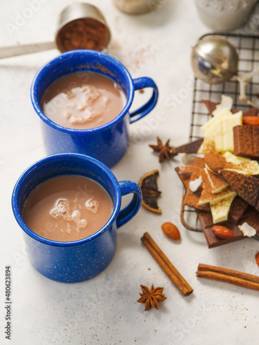 Two blue cups of coffee, coffee with milk, cocoa, chocolate pieces, decor on a white background. Home comfort, romance, date. Restaurant, cafe, hotel, confectionery, menu design, advertising.