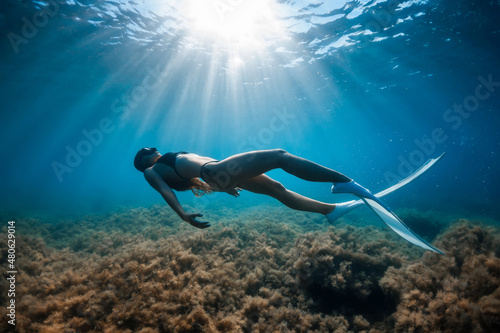 Free diver woman with white fins posing underwater. Freediving with young girl