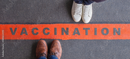 Vaccination and anti-vaccination concept. Two people standing opposite each other, divided by a red line and their opinions about vaccine. photo