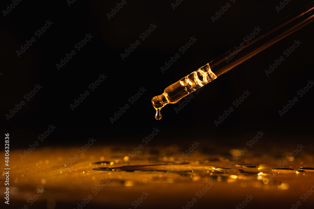 cosmetic pipette with cosmetic oil, perfume, essence, on a black background, gold-colored liquid. - obrazy, fototapety, plakaty 