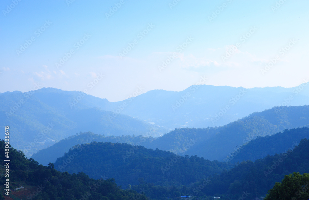 Mountain range with visible silhouettes through the morning colorful fog.with sunlight romanctic moment Mountain range with visible silhouettes through the morning colorful fog.with sunlight romanctic moment