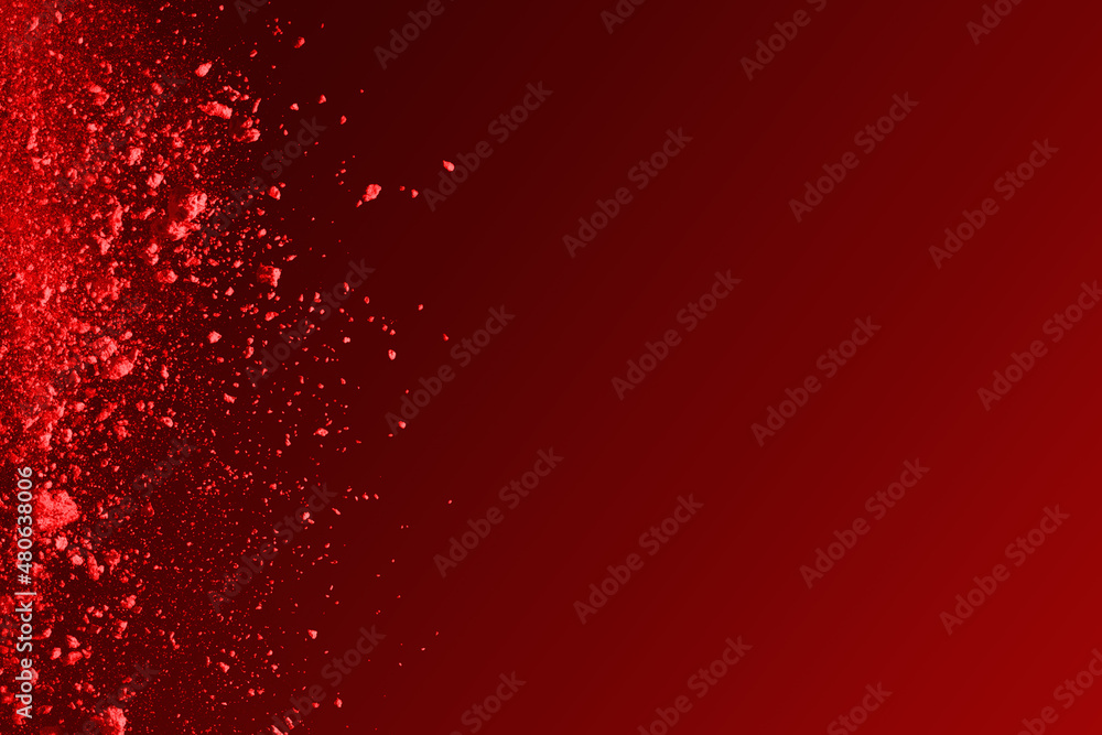 Red powder explosion on red background.