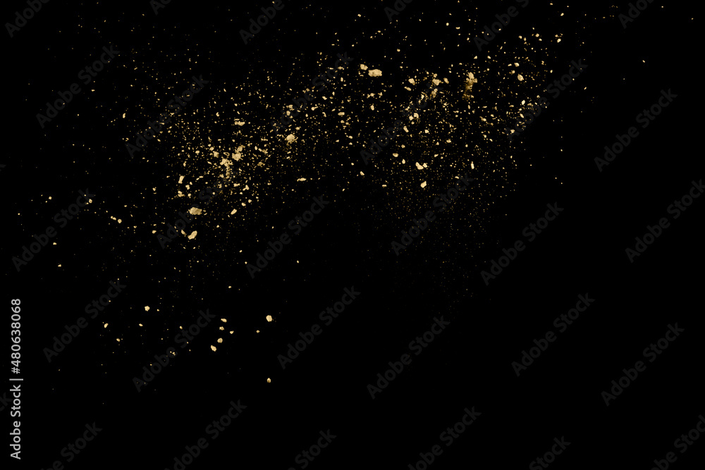 Fototapeta premium Golden powder explosion on black background. Freeze motion.