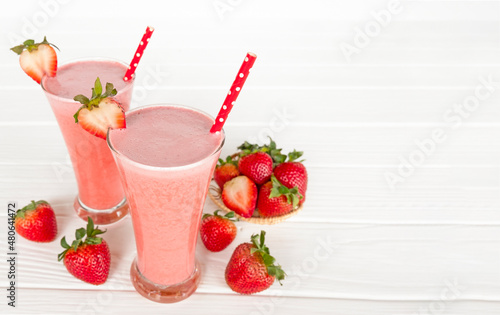 Strawberry yogurt fruit juice smoothie pink colorful fruit juice milkshake blend beverage healthy high protein the taste yummy In glass drink episode morning on white wood background.