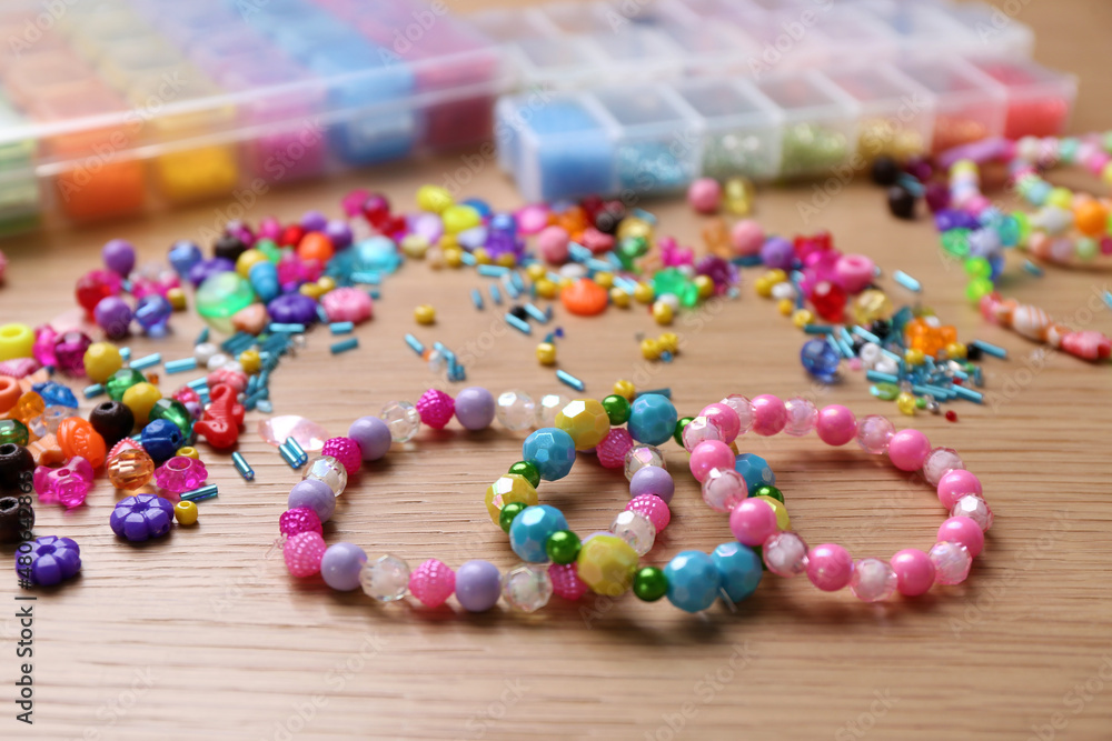 Beautiful handmade beaded bracelets and supplies on wooden table Beautiful handmade beaded bracelets and supplies on wooden table