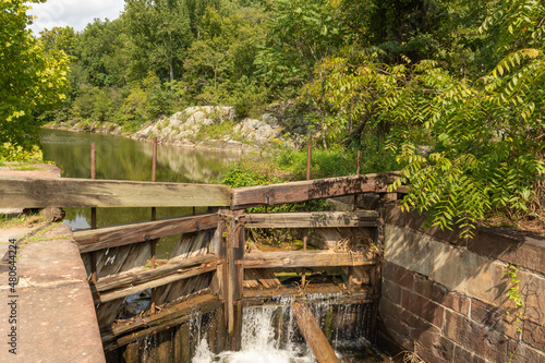 Water pours through a broken canal gate into the lock on a late summer afternoon.