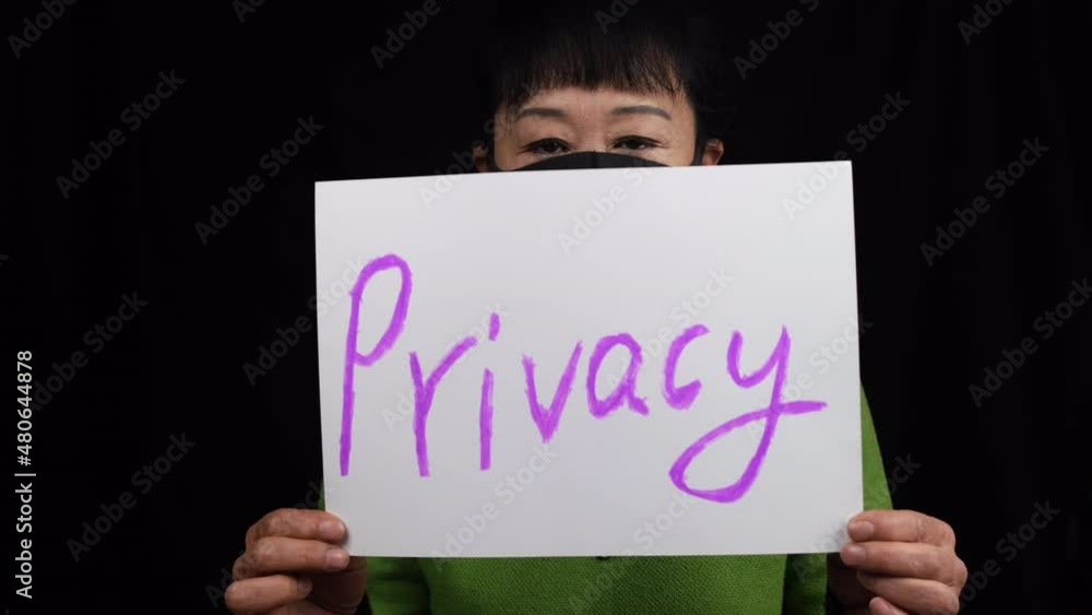 Asian middle-aged woman with mask holding Privacy poster for women's rights. Asian middle-aged woman with mask holding Privacy poster for women's rights.
