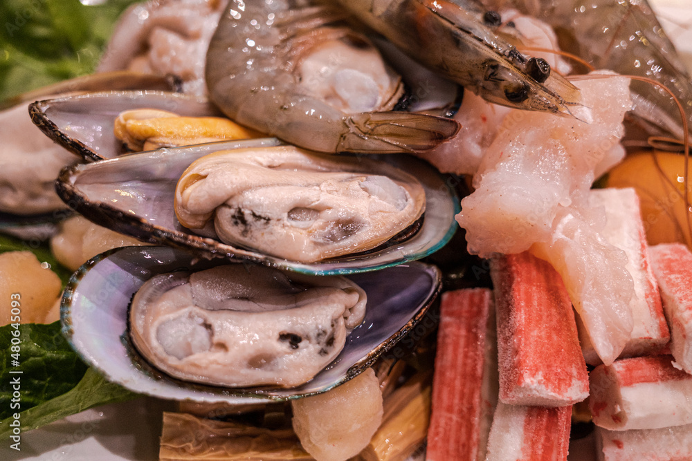 Selective focus at raw seafood ingredient for hotpot, asian sukiyaki, mussels crab sticks, fish and shrimp. Selective focus at raw seafood ingredient for hotpot, asian sukiyaki, mussels crab sticks, fish and shrimp.