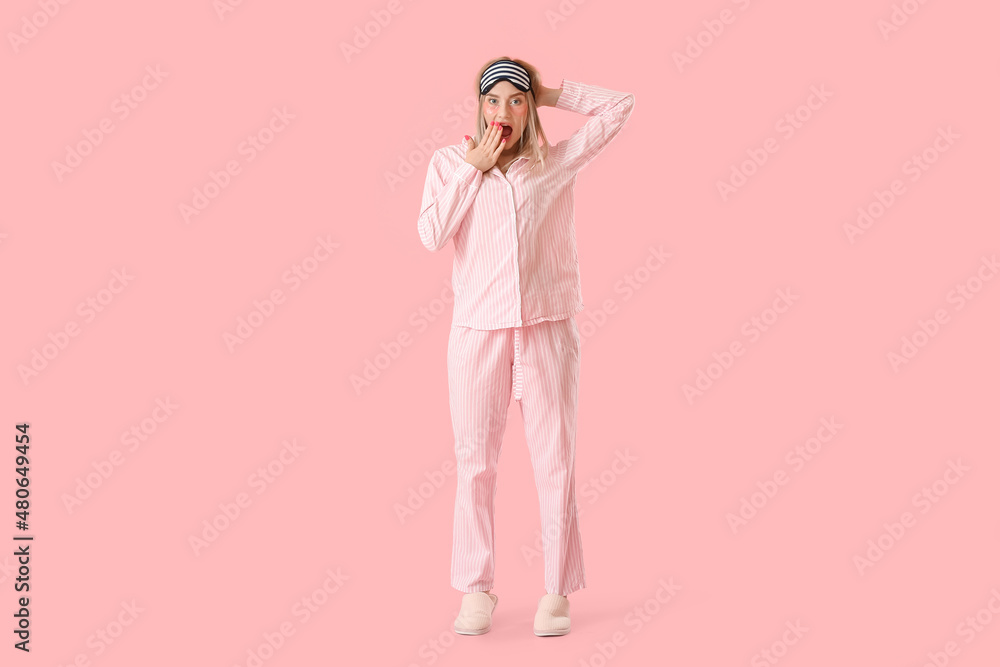 Shocked young woman with sleeping mask and under-eye patches on pink background Shocked young woman with sleeping mask and under-eye patches on pink background