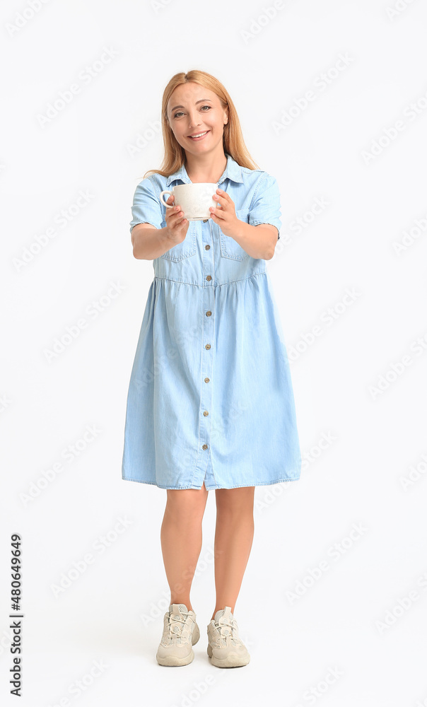 Beautiful mature woman with cup of coffee on light background Beautiful mature woman with cup of coffee on light background