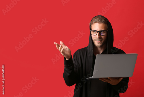 Hacker with laptop on color...