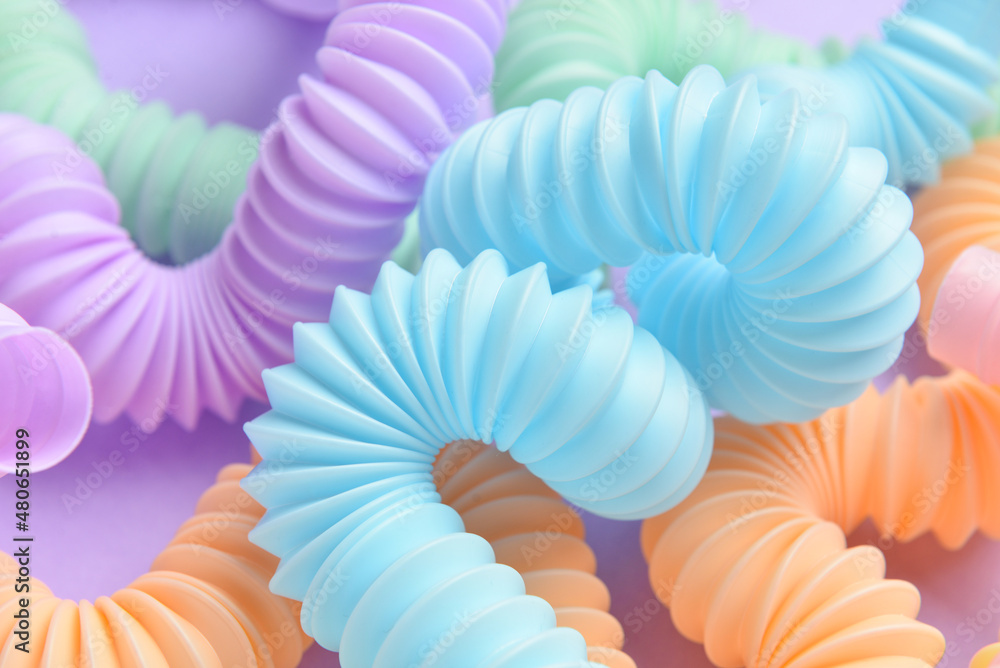 Different colorful Pop Tubes on purple background, closeup Different colorful Pop Tubes on purple background, closeup