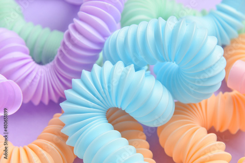 Different colorful Pop Tubes on purple background, closeup photo