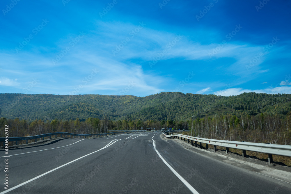 A landscape with a winding highway under a cloudy sky.