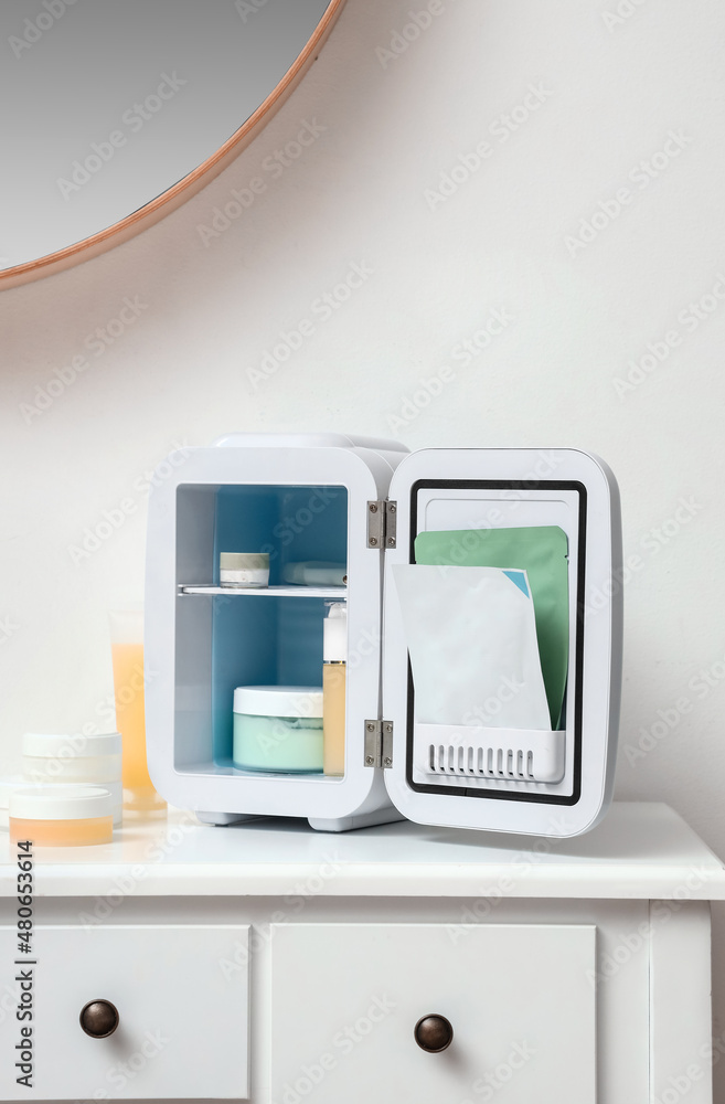 Small cosmetic refrigerator on table in room Small cosmetic refrigerator on table in room