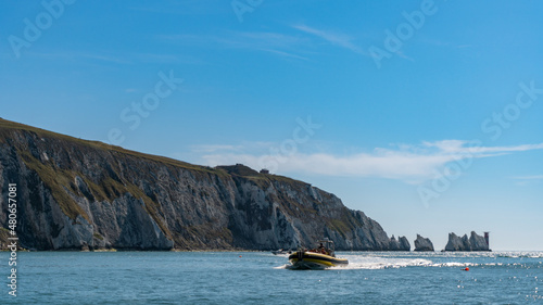 Far away view of the Needles and a boat, in Alum Bay, Isle of Wight, United Kingdom photo