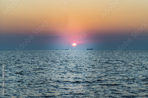 Beautiful sunset over a calm sea with a blue and orange glowing sky. Space for text, Selective focus. © num